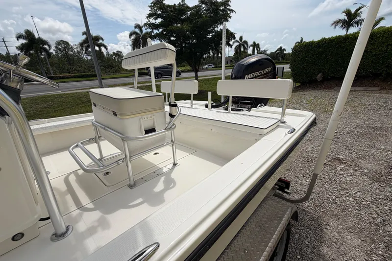 Slide: The Image of 2017 Mako 21 LTS boat with Mercury engine, parked on gravel near palm trees. - 6