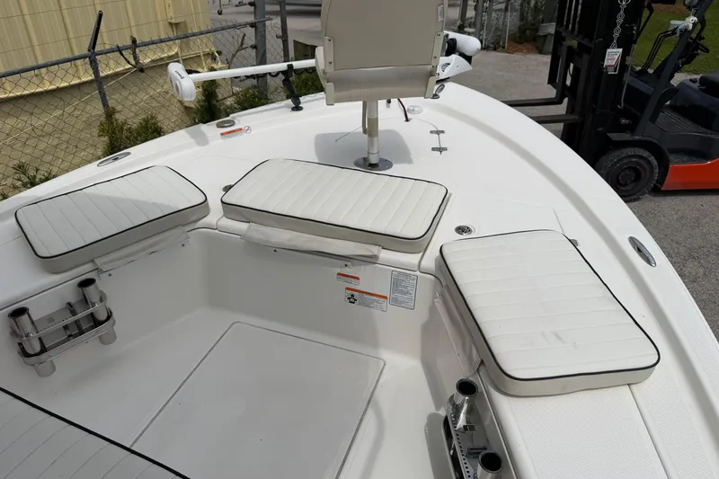 Slide: The Image of 2017 Mako 21 LTS boat interior with cushioned seating and rod holders. - 8