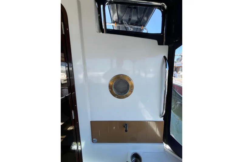 Slide: The Image of 2017 Ranger Tugs R-27 boat interior with porthole and stainless steel handle. - 11