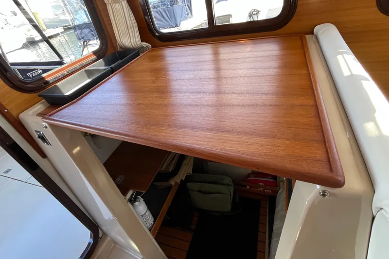 Slide: The Image of Interior of 2017 Ranger Tugs R-27 with wooden table and window view. - 16
