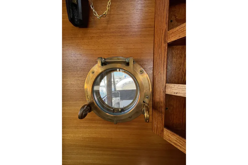Slide: The Image of Brass porthole on 2017 Ranger Tugs R-27 boat, wooden interior detail. - 21