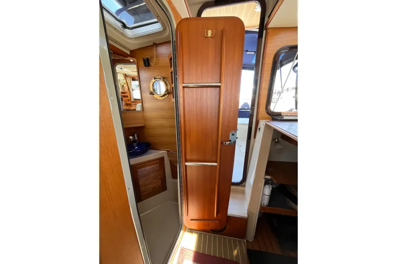 Slide: The Image of Interior view of 2017 Ranger Tugs R-27 boat, featuring wooden door and nautical decor. - 23
