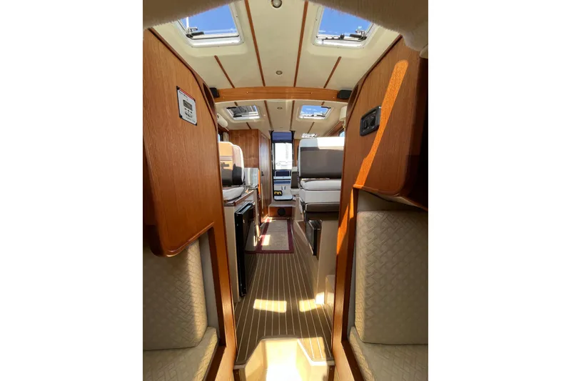 Slide: The Image of Interior of 2017 Ranger Tugs R-27 boat, featuring wood finishes and skylights. - 31