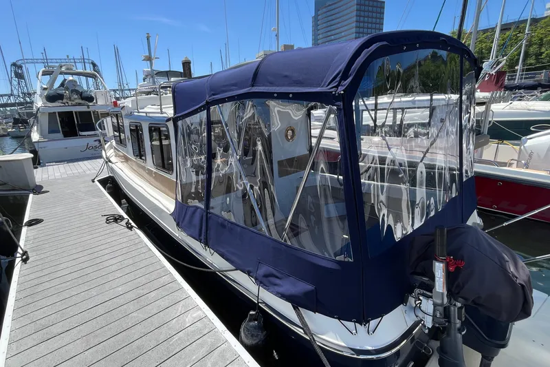 Slide: The Image of 2017 Ranger Tugs R-27 docked at marina with blue canopy and clear windows. - 7