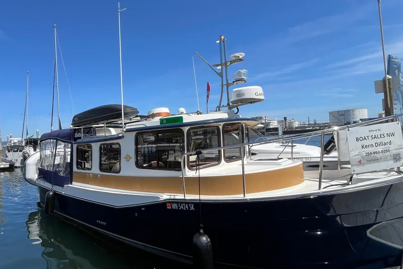 Slide: The Image of 2017 Ranger Tugs R-27 boat docked at marina under clear blue sky. - 9