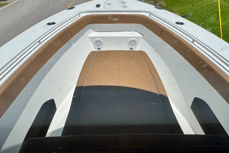 Slide: The Image of 2024 Sea Hunt Gamefish 27 Coffin Box boat interior with cushioned seating and speakers. - 13