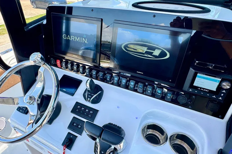 Slide: The Image of 2024 Sea Hunt Gamefish 27 Coffin Box dashboard with Garmin displays and JL Audio system. - 16