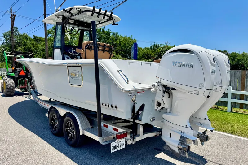 Slide: The Image of 2024 Sea Hunt Gamefish 27 Coffin Box boat with dual Yamaha engines on a trailer. - 2