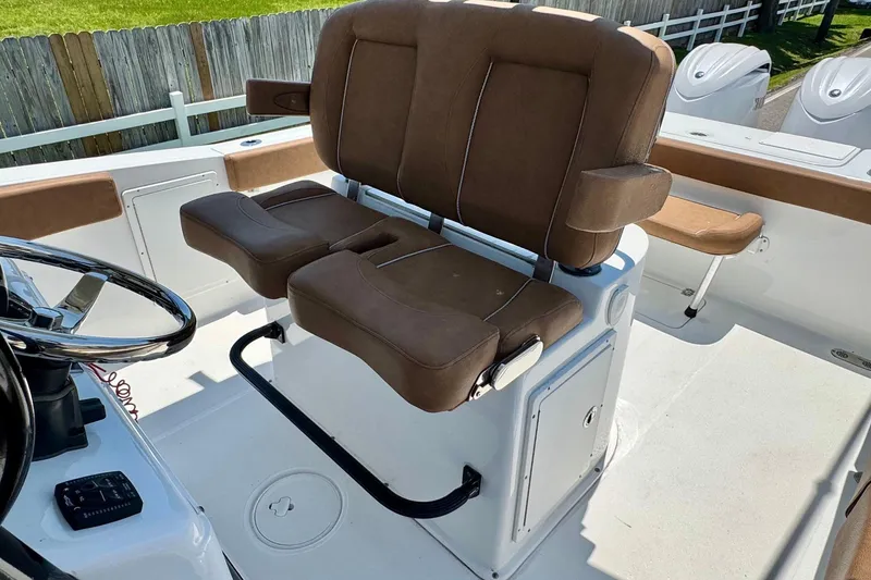 Slide: The Image of 2024 Sea Hunt Gamefish 27 Coffin Box boat interior with brown seating and steering wheel. - 9