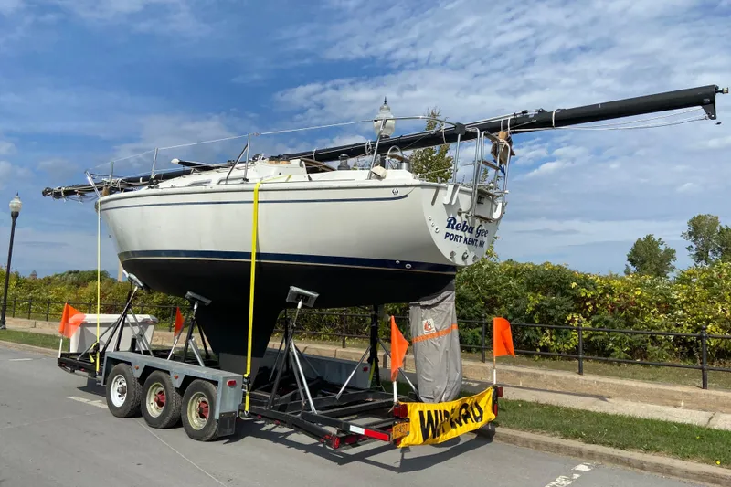 Slide: The Image of 1987 Ericson 28/2 sailboat on trailer, ready for transport under a clear blue sky. - 2