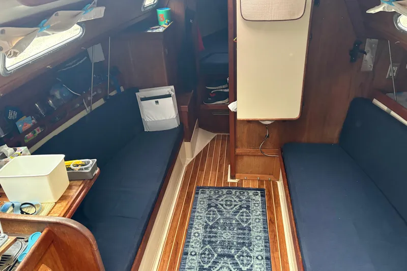 Slide: The Image of Interior of 1987 Ericson 28/2 sailboat with blue seating and wooden flooring. - 26