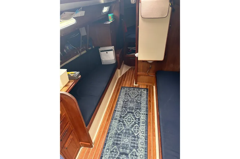 Slide: The Image of Interior of 1987 Ericson 28/2 sailboat with wooden flooring and blue seating. - 27