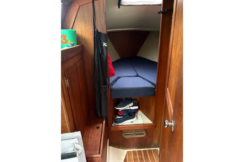 Slide: The Image of Cozy cabin interior of 1987 Ericson 28/2 sailboat with wooden finish and blue bedding. - 30