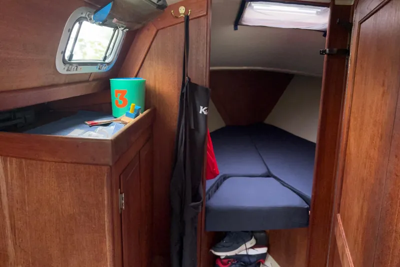 Slide: The Image of Cozy cabin interior of a 1987 Ericson 28/2 sailboat with wooden finishes and a small berth. - 31