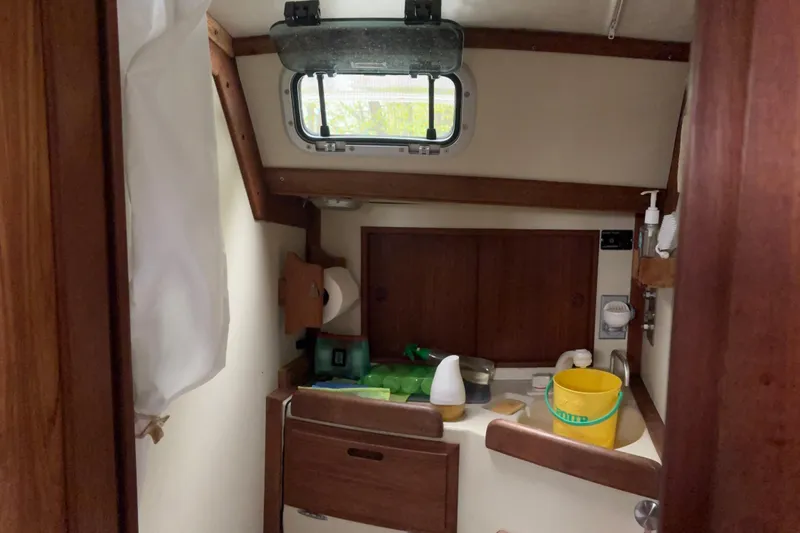 Slide: The Image of Compact bathroom interior of a 1987 Ericson 28/2 sailboat with wooden cabinetry. - 33