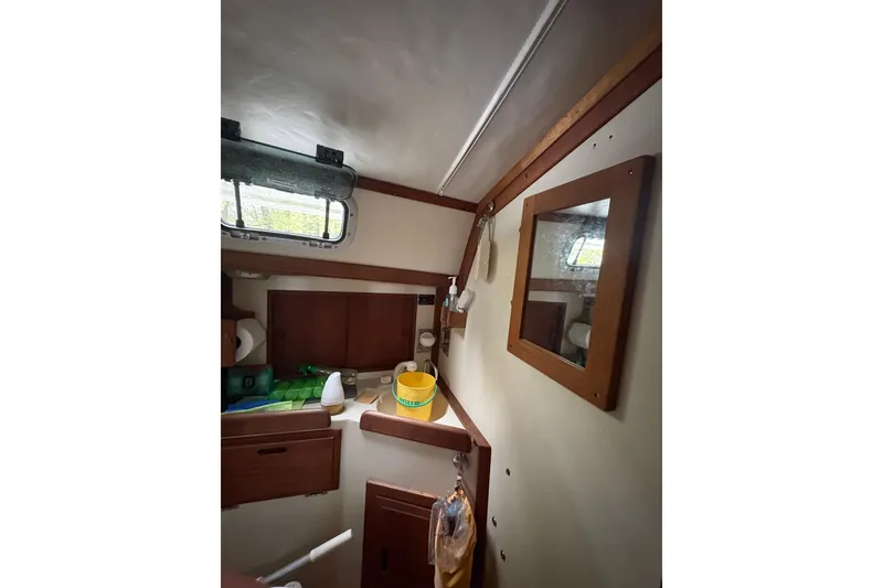 Slide: The Image of Interior of 1987 Ericson 28/2 sailboat, featuring a compact cabin with wooden accents. - 35