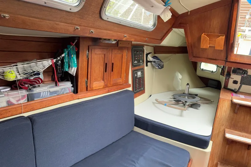 Slide: The Image of Interior of a 1987 Ericson 28/2 sailboat with wooden cabinetry and blue seating. - 38