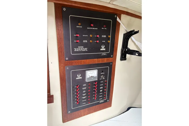 Slide: The Image of Electrical control panel on a 1987 Ericson 28/2 sailboat, featuring switches and gauges. - 39