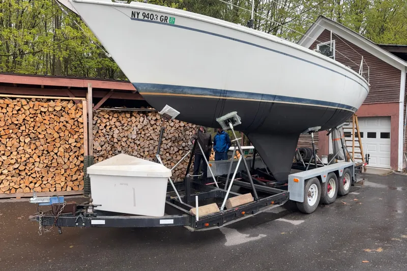 Slide: The Image of 1987 Ericson 28/2 sailboat on trailer, parked near woodpile and garage. - 4