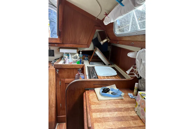 Slide: The Image of Interior of 1987 Ericson 28/2 sailboat galley with wooden cabinetry and kitchen essentials. - 40