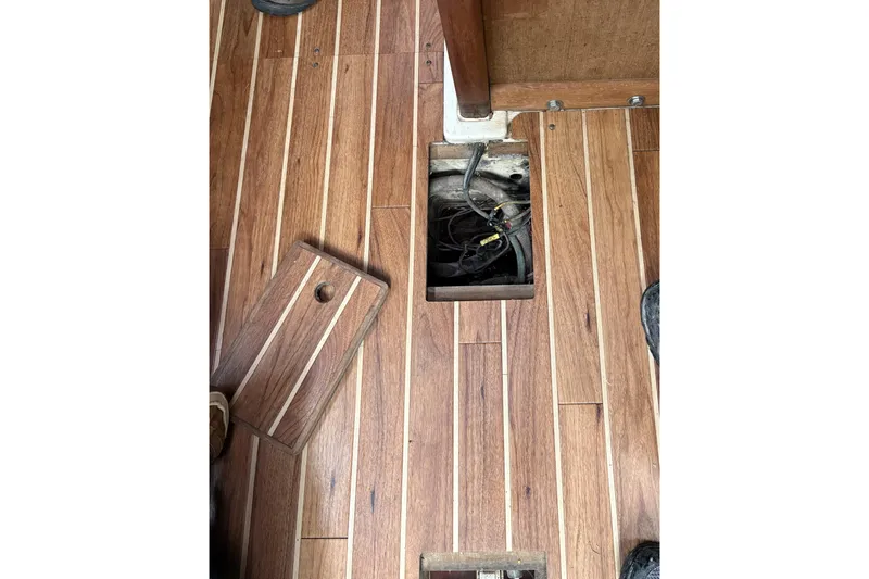Slide: The Image of Wooden floor with open hatch revealing wiring on a 1987 Ericson 28/2 sailboat. - 43