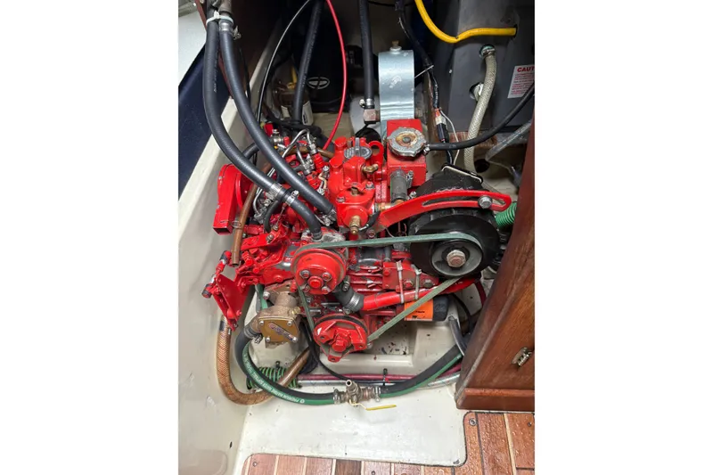 Slide: The Image of 1987 Ericson 28/2 sailboat engine, featuring red components and various hoses. - 45