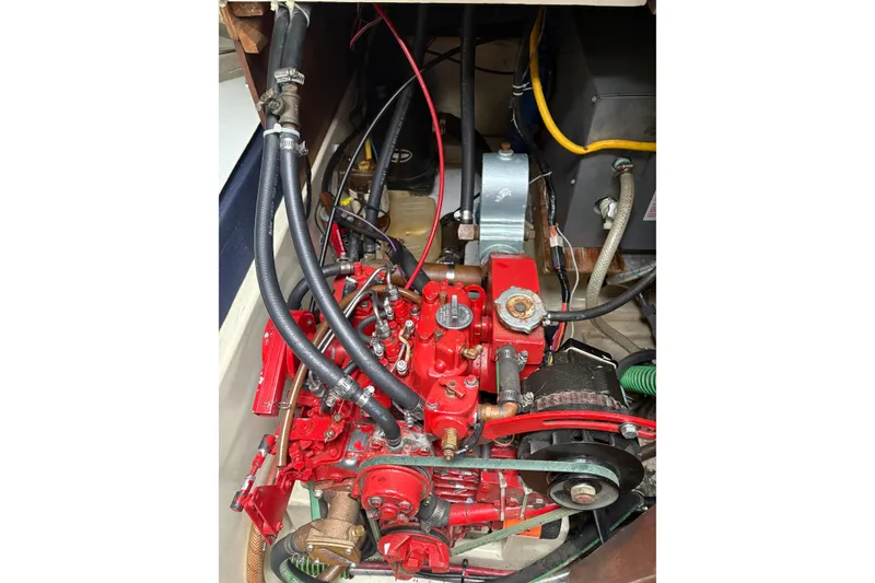 Slide: The Image of Engine compartment of a 1987 Ericson 28/2 sailboat, featuring red mechanical components. - 46