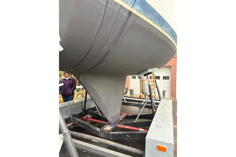 Slide: The Image of 1987 Ericson 28/2 sailboat on trailer, showing hull and keel in a garage setting. - 5