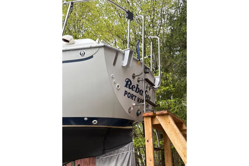 Slide: The Image of 1987 Ericson 28/2 sailboat stern view with ladder, surrounded by trees. - 7