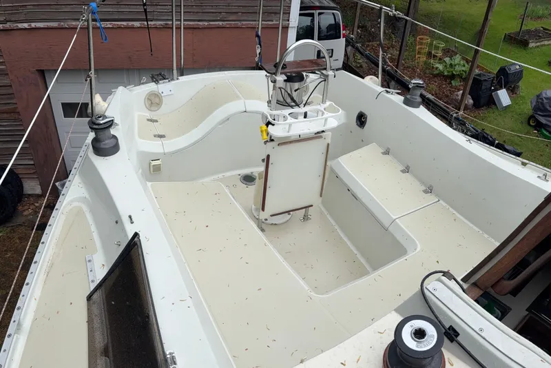 Slide: The Image of 1987 Ericson 28/2 sailboat cockpit with steering wheel, winches, and seating, parked outdoors. - 9