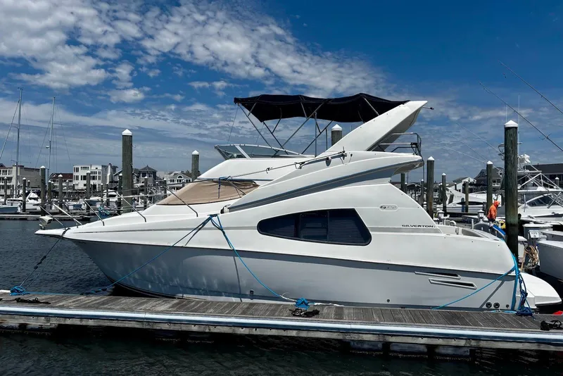 The Image of 2001 Silverton 330 Sport Bridge yacht docked at marina under blue sky. - 0