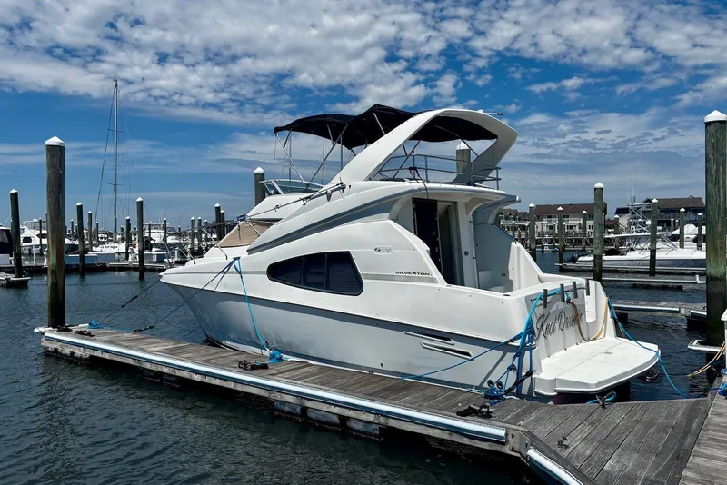 Slide: The Image of 2001 Silverton 330 Sport Bridge yacht docked at marina under blue sky. - 1