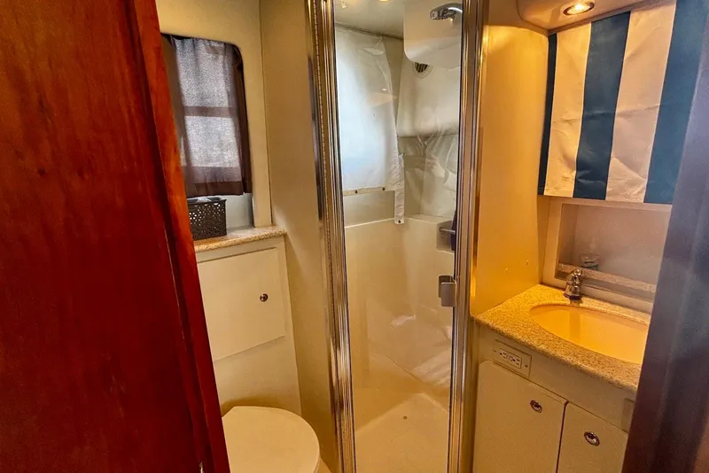 Slide: The Image of 2001 Silverton 330 Sport Bridge bathroom with shower, sink, and toilet. - 11