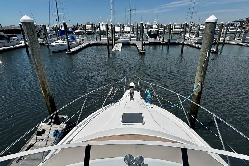 Slide: The Image of 2001 Silverton 330 Sport Bridge yacht docked in a marina, surrounded by boats. - 2