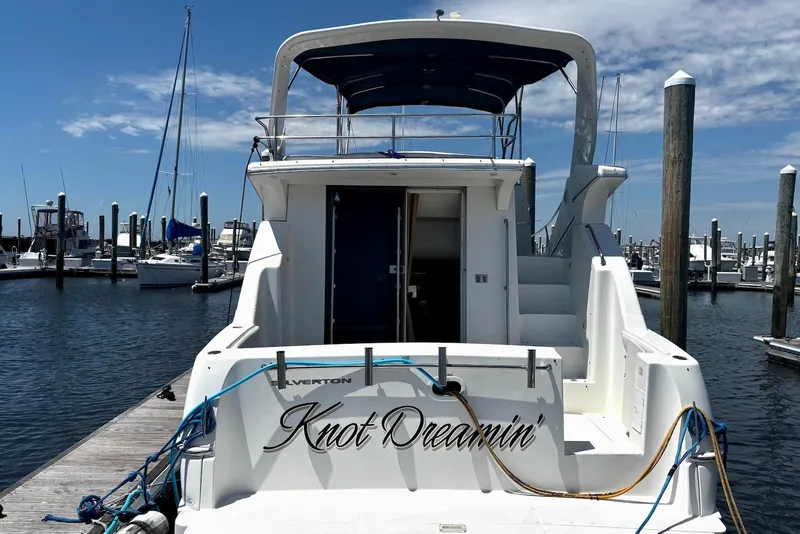 Slide: The Image of 2001 Silverton 330 Sport Bridge yacht docked at marina under clear blue sky. - 3