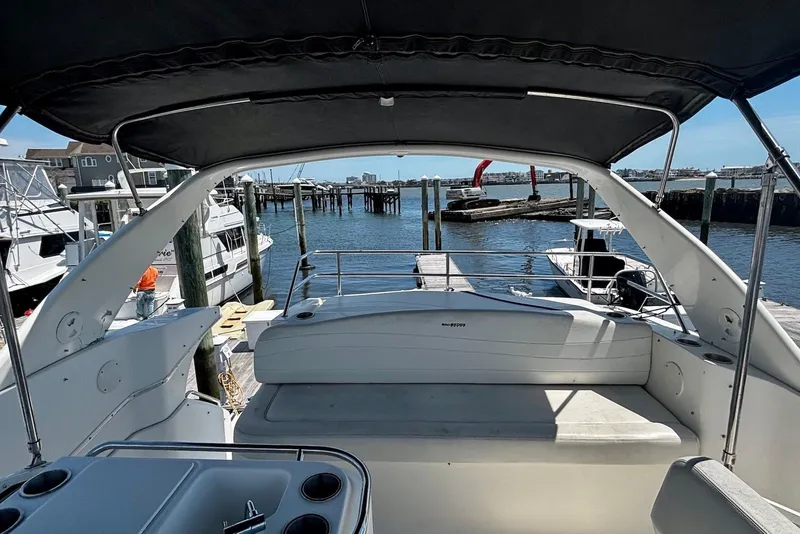 Slide: The Image of 2001 Silverton 330 Sport Bridge yacht docked at marina, featuring spacious seating and water view. - 4