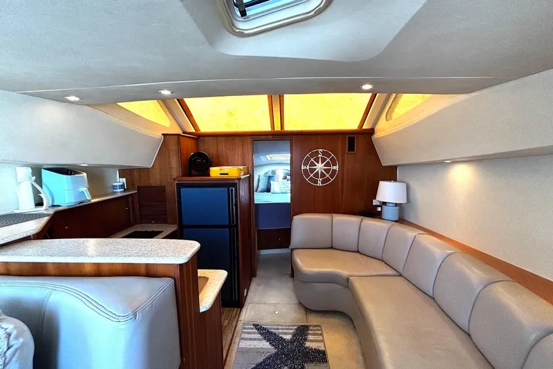 Slide: The Image of Interior of 2001 Silverton 330 Sport Bridge yacht with modern seating and kitchenette. - 7