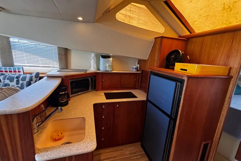 Slide: The Image of Interior of 2001 Silverton 330 Sport Bridge yacht kitchen with appliances and wood cabinetry. - 8