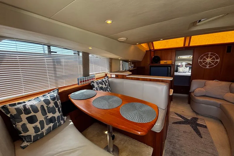 Slide: The Image of Interior of 2001 Silverton 330 Sport Bridge yacht with dining area and cozy seating. - 9