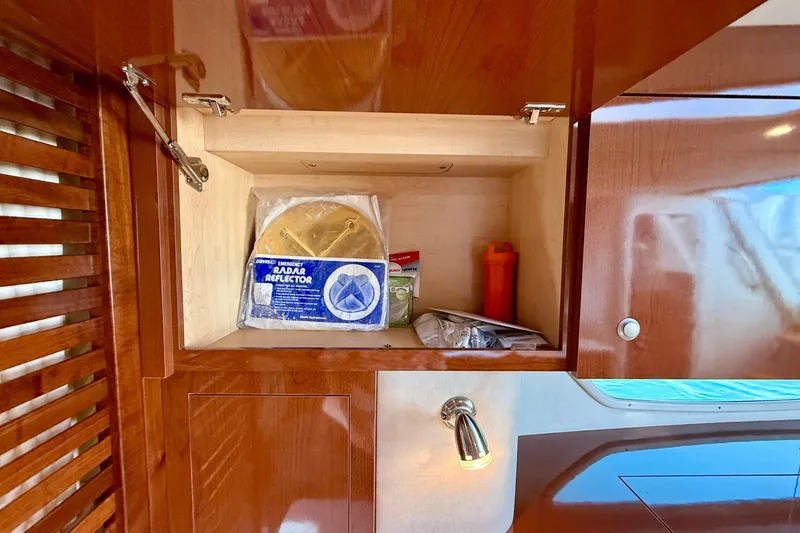 Slide: The Image of Cabinet interior on 2009 Sea Ray Sundancer 350 with emergency supplies and radar reflector. - 14