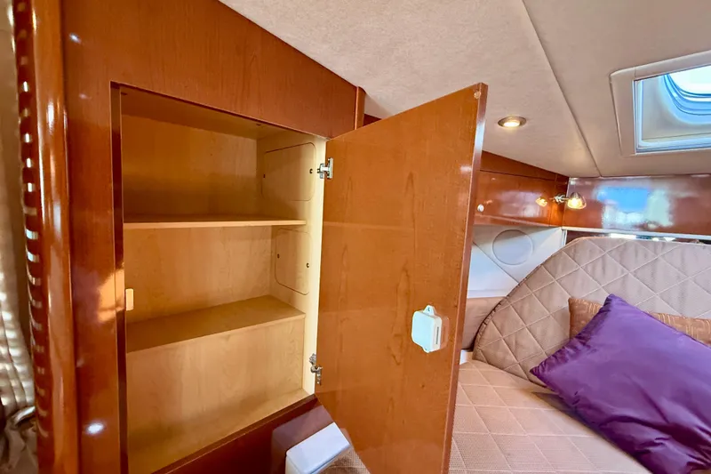 Slide: The Image of Interior of 2009 Sea Ray Sundancer 350 with open wooden cabinet and cozy seating area. - 20