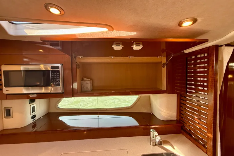Slide: The Image of Interior of 2009 Sea Ray Sundancer 350 yacht kitchen with microwave and wooden cabinetry. - 28