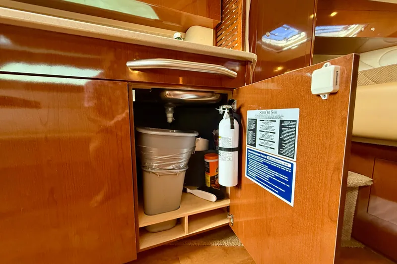 Slide: The Image of 2009 Sea Ray Sundancer 350 interior cabinet with fire extinguisher and cleaning supplies. - 36