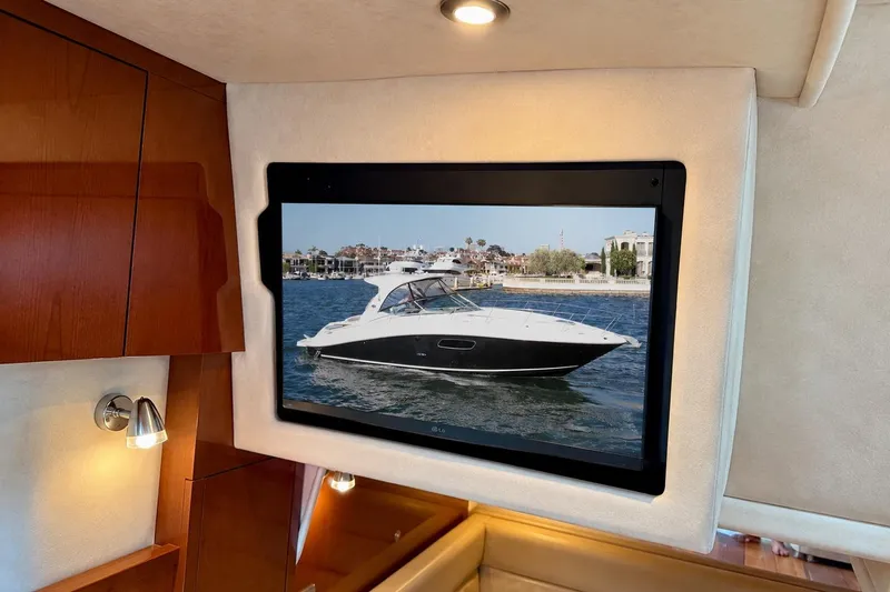 Slide: The Image of Interior of a 2009 Sea Ray Sundancer 350 with a wall-mounted screen displaying a yacht. - 37