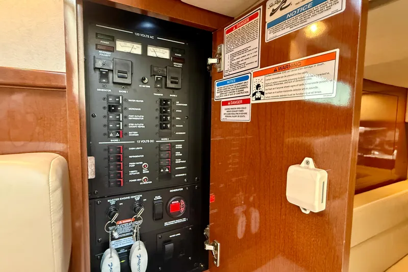Slide: The Image of Electrical control panel inside 2009 Sea Ray Sundancer 350 yacht cabin with safety notices. - 47