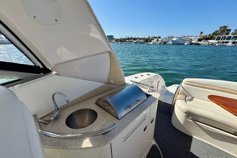 Slide: The Image of 2009 Sea Ray Sundancer 350 yacht interior with kitchenette and seating, overlooking marina. - 55