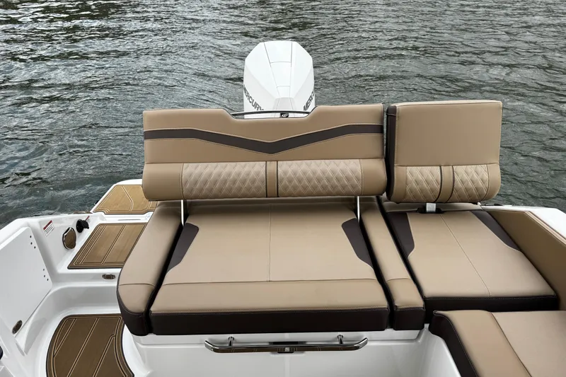 Slide: The Image of 2026 Monterey Elite 25 OB boat with luxurious tan seating on water. - 10
