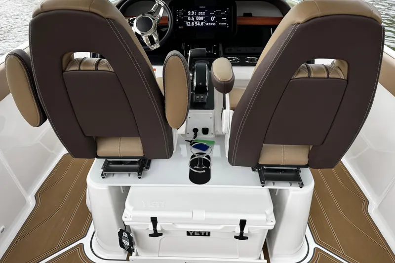 Slide: The Image of 2026 Monterey Elite 25 OB boat interior with dual brown seats and Yeti cooler. - 12