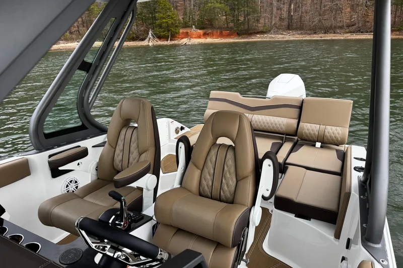 Slide: The Image of 2026 Monterey Elite 25 OB boat interior with luxurious seating on a serene lake. - 14