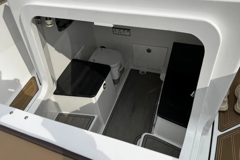 Slide: The Image of Interior view of 2026 Monterey Elite 25 OB boat cabin with seating and storage. - 20